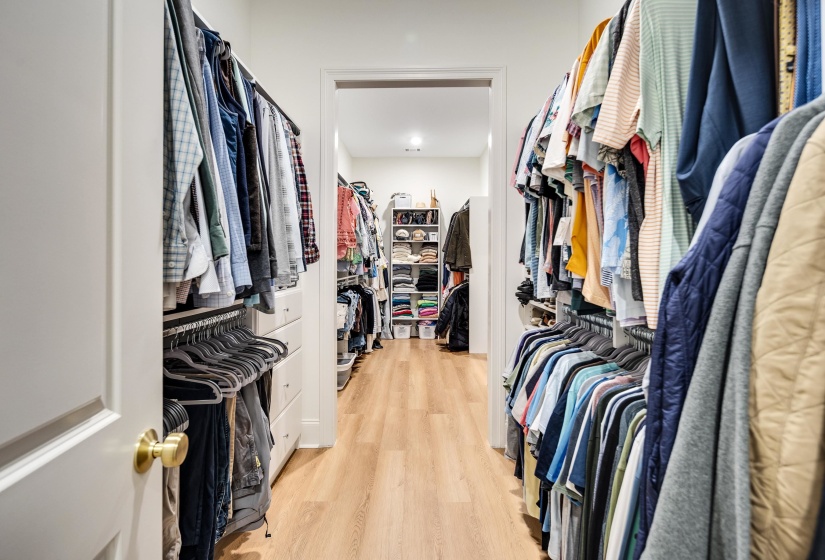 Walk-in closet featuring wood-finish flooring, recessed lighting, and extensive built-in shelving