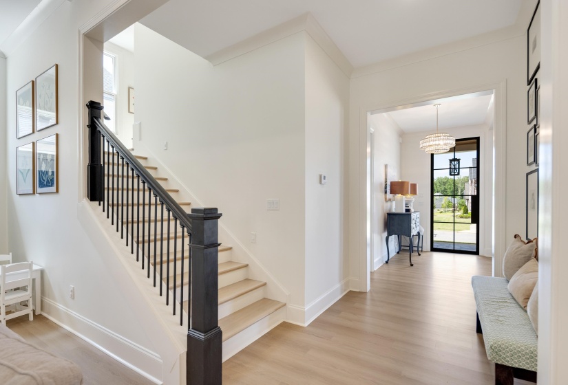 Entryway featuring light wood-finish flooring, white walls, and crown molding