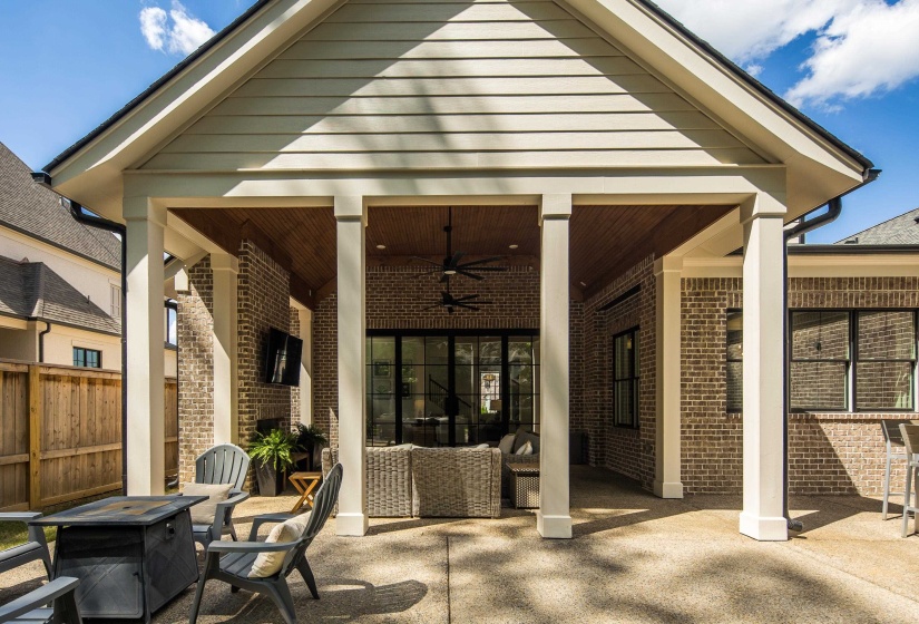 Expansive covered patio featuring a wood-plank ceiling, brick exterior walls, and recessed lighting