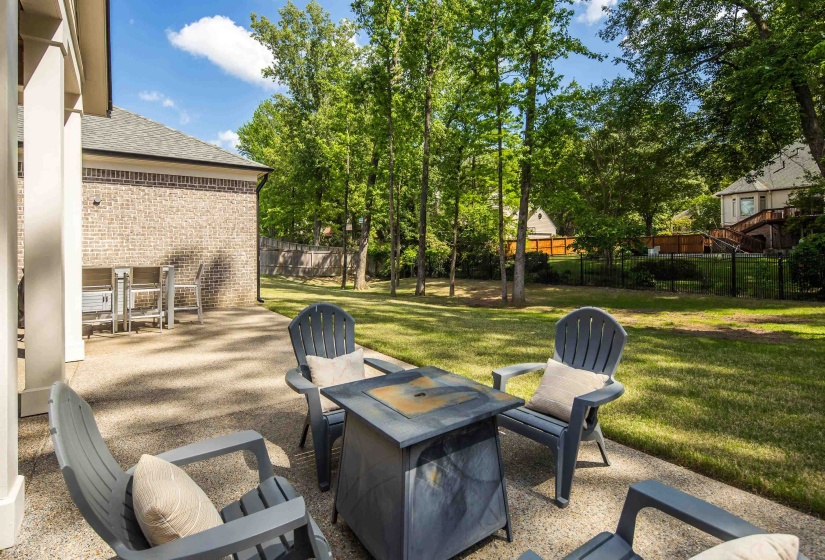 Expansive backyard featuring a lush lawn, mature trees, and a privacy fence