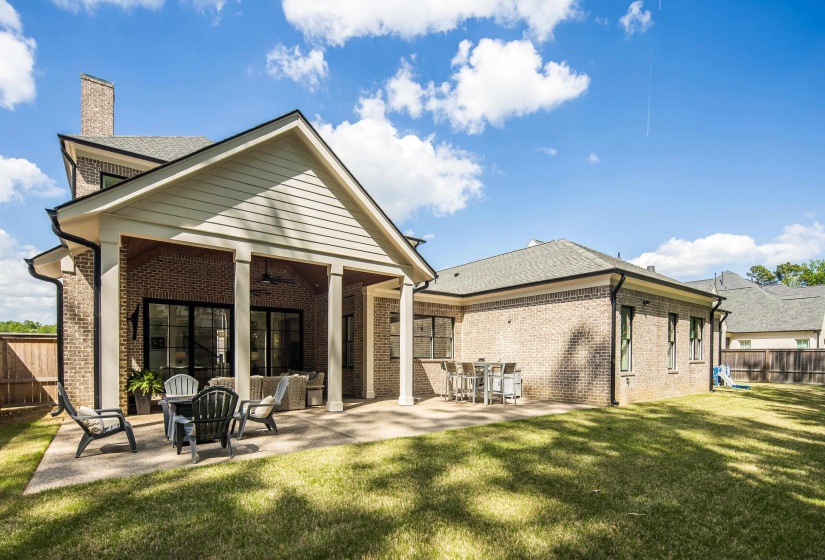 Brick exterior featuring a covered patio with columns and a ceiling fan
