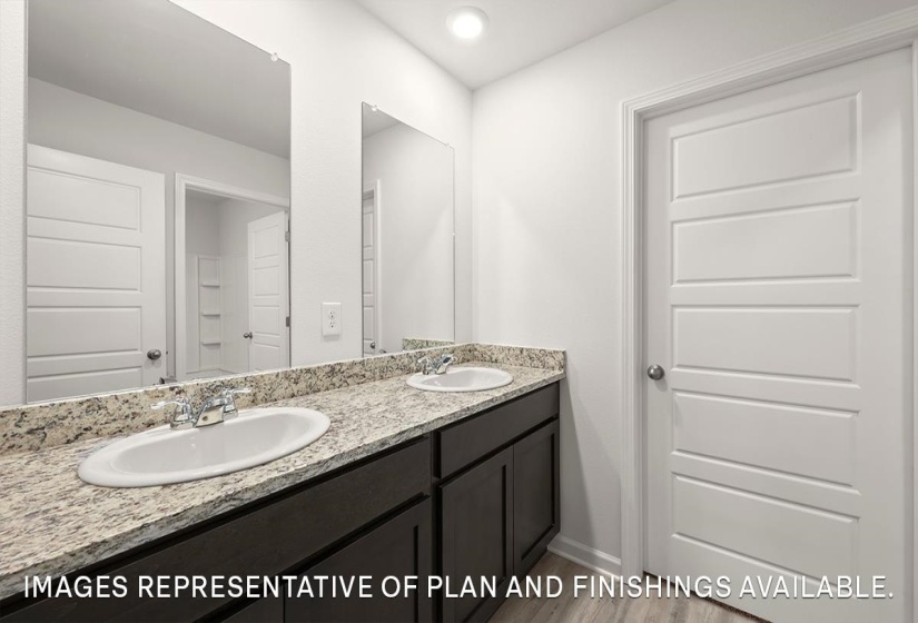 Bathroom featuring double vanity, recessed lighting, and wood finished floors