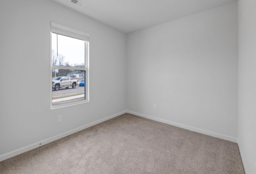 Neutral painted walls, plush carpet flooring, white trim, and a window with blinds