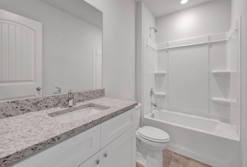 Bathroom featuring a white vanity with an integrated rectangular sink, speckled countertop, and chrome faucet