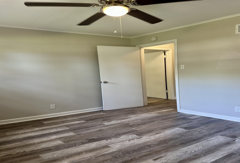 Interior room featuring wood-finish flooring, light neutral wall paint, and white trim