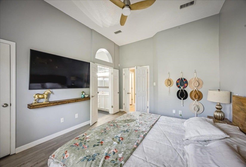 Vaulted ceilings enhance this room featuring wood-finish flooring and light gray walls