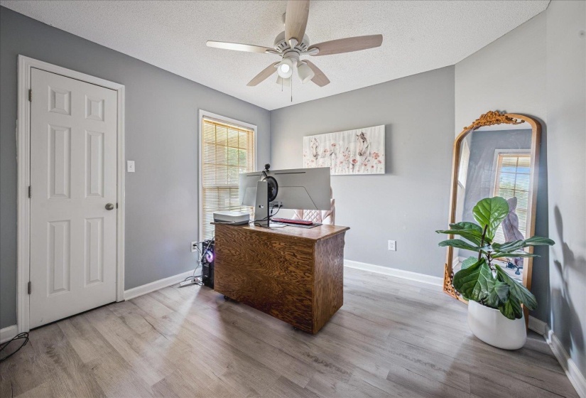 Room featuring light gray walls, wood-finish flooring, and a multi-pane window
