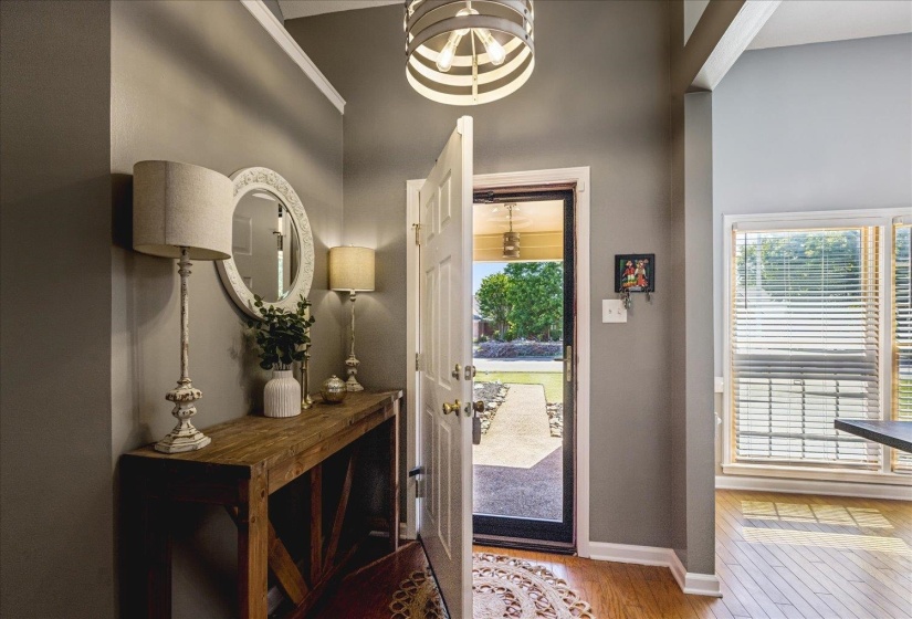 Foyer featuring a wood-finish floor, tray ceiling, and a modern drum chandelier