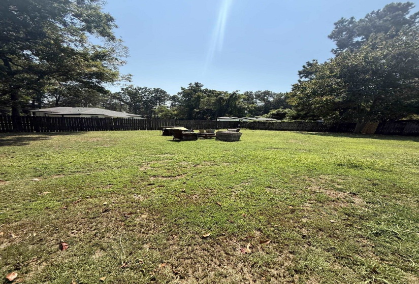 Expansive green lawn with a privacy fence