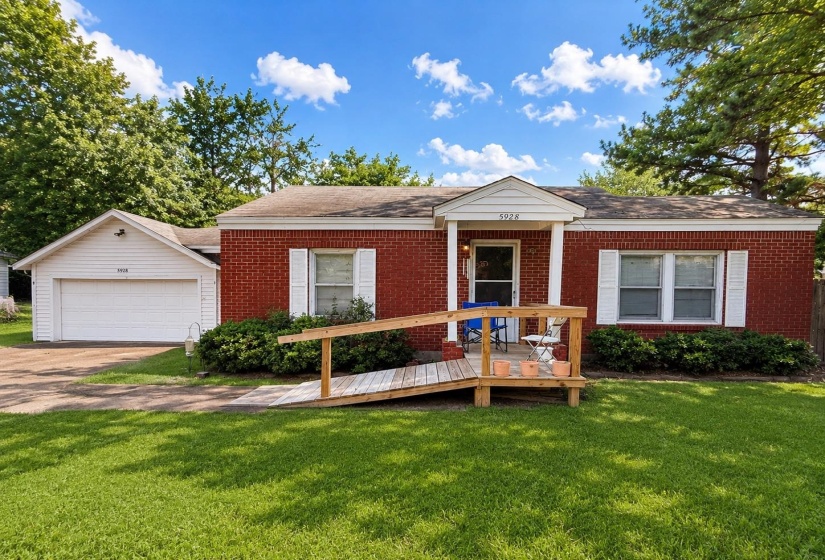 Brick exterior featuring white shutters and a covered entry