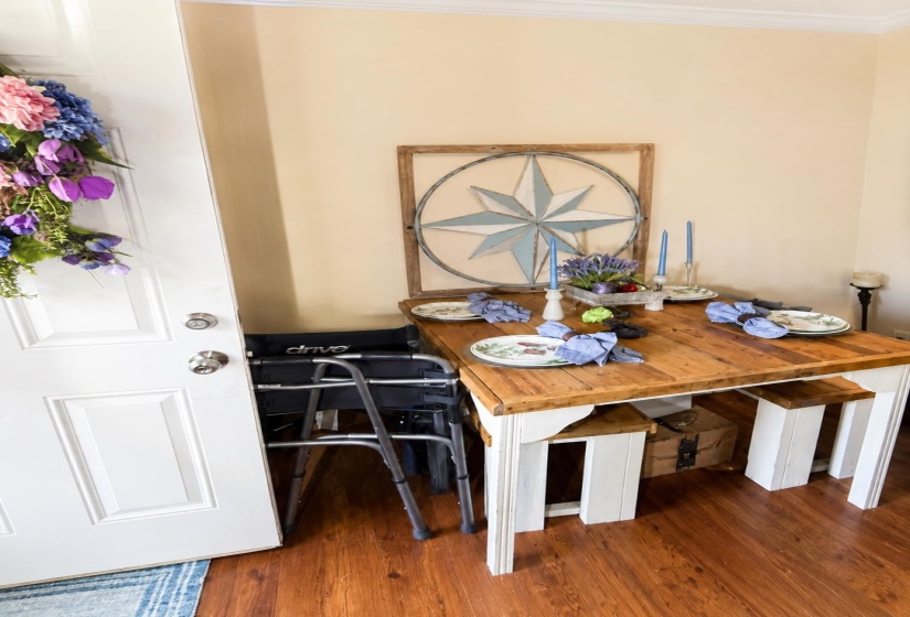 Hardwood-finish flooring complementing a solid wood-top table with white painted legs and matching benches