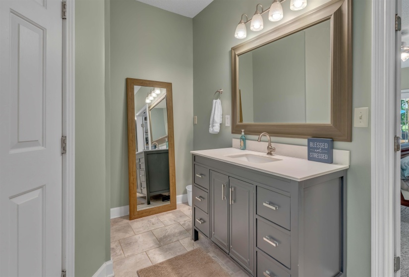 Bathroom featuring a gray vanity with shaker-style cabinetry, a white countertop, and an undermount sink