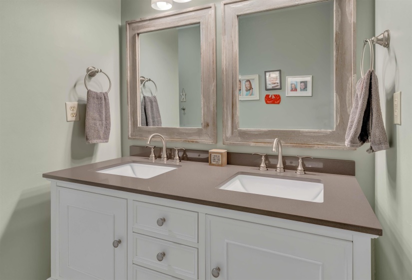 Dual vanity with white cabinetry, square inset sinks, and a dark countertop