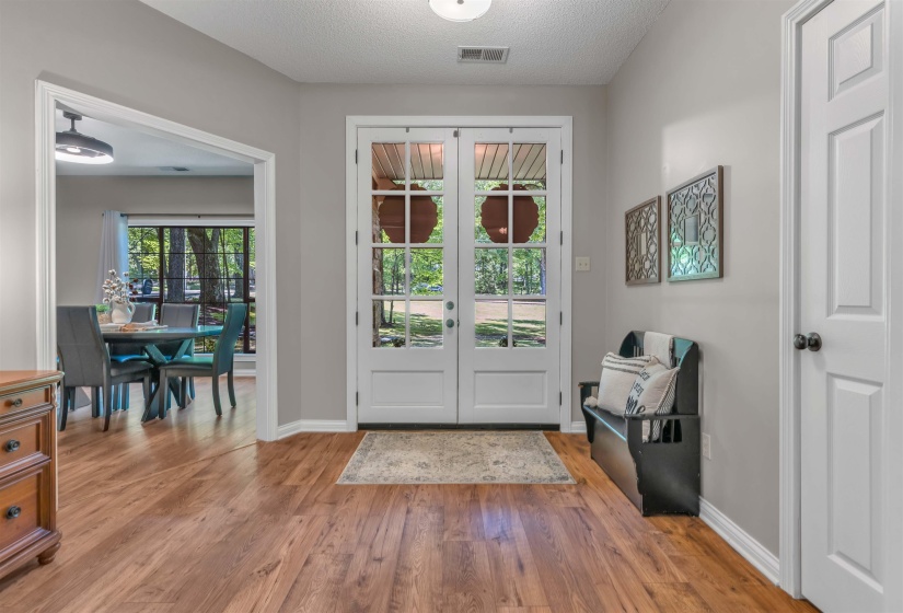 Entryway featuring wood-finish flooring, light gray wall paint, and white trim
