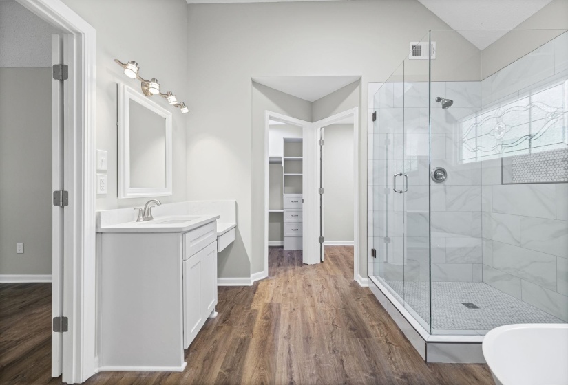 Bathroom featuring a stall shower, vanity, dark wood-style floors, and a spacious closet