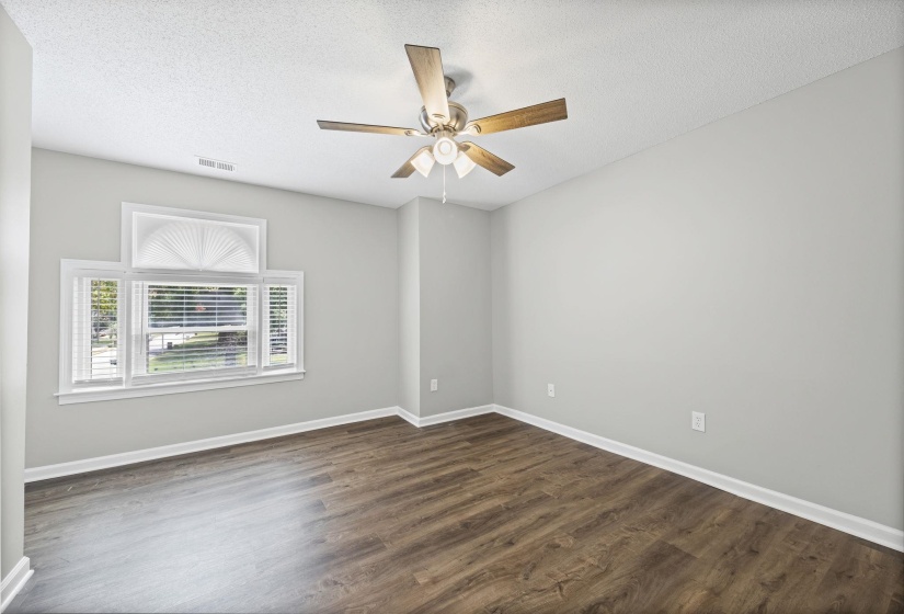 Unfurnished room featuring a textured ceiling, dark wood-type flooring, and a ceiling fan