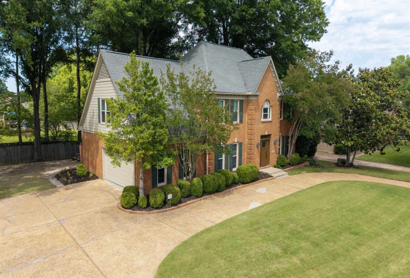 Traditional brick exterior featuring a multi-gabled roof and an attached garage