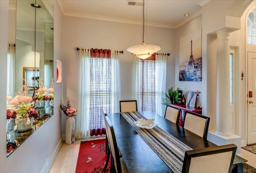 Dining area with wood-finish flooring, crown molding, and recessed lighting