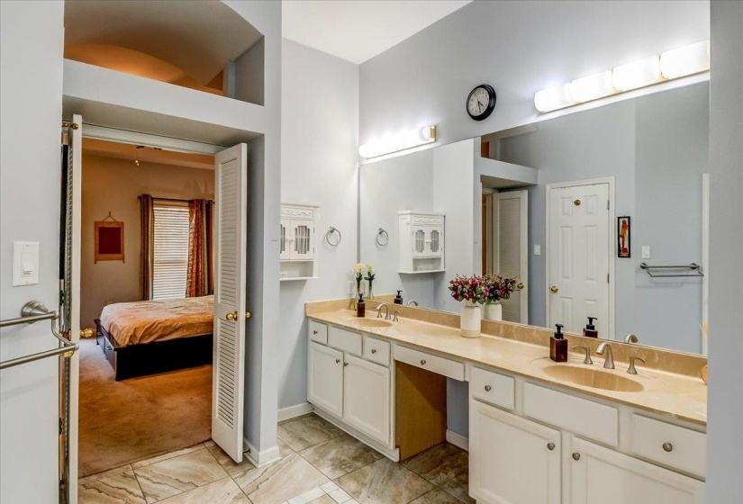 Dual vanity with integrated sinks, ample countertop space, and white cabinetry