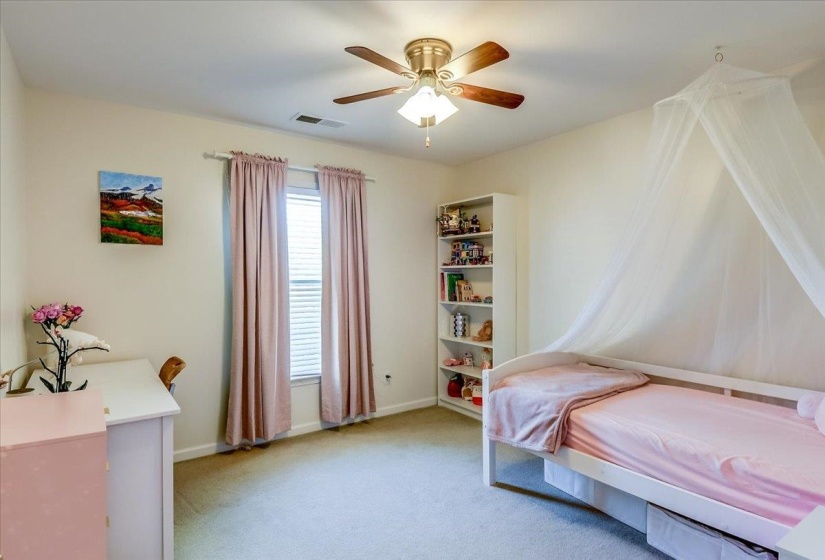 Carpeted room with a ceiling fan light fixture