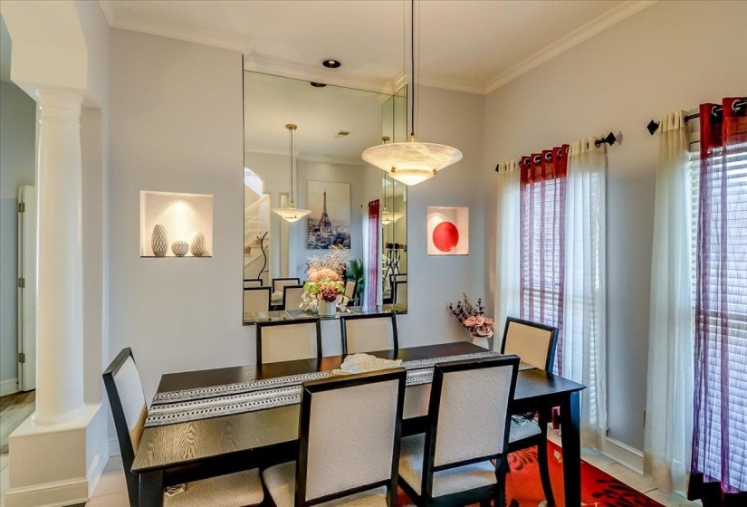 Dining area with crown molding and a prominent decorative column