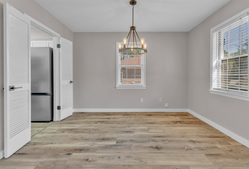 Spacious room featuring wood-finish flooring, light grey walls, and white trim