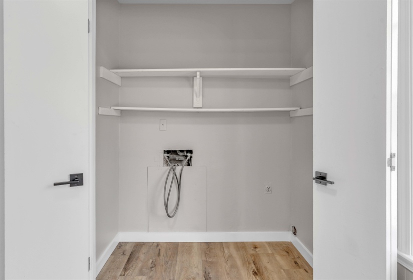 Dedicated utility space with wood-finish flooring and light gray wall paint
