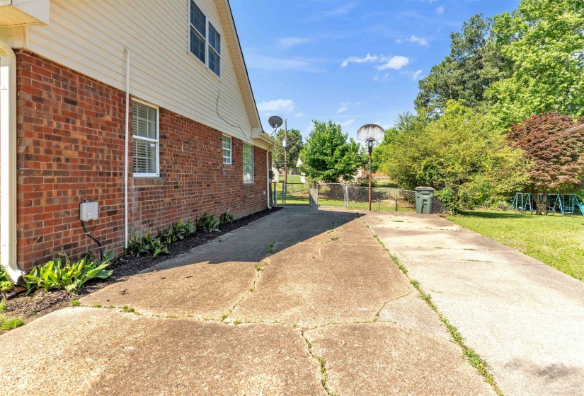 Exterior featuring brick and siding finishes, multiple windows, and a concrete pathway