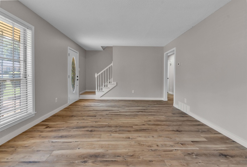 Spacious interior featuring wood-finish flooring, light gray wall paint, and white trim