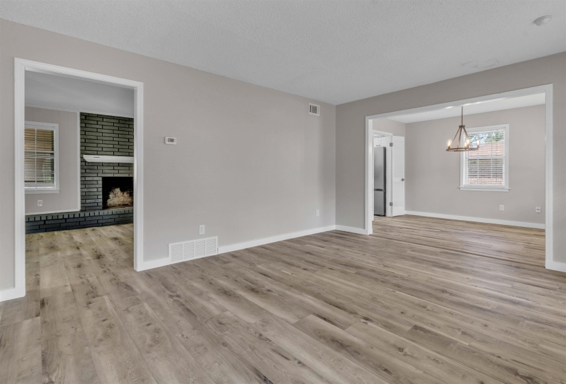 Spacious room featuring wood-finish flooring, light gray wall paint, and white baseboards