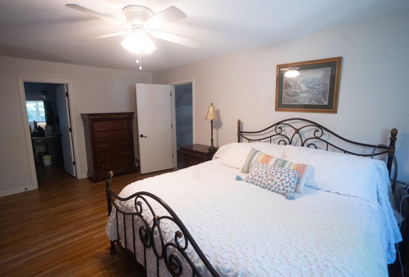 Hardwood flooring, light gray walls, and a ceiling fan with integrated lighting