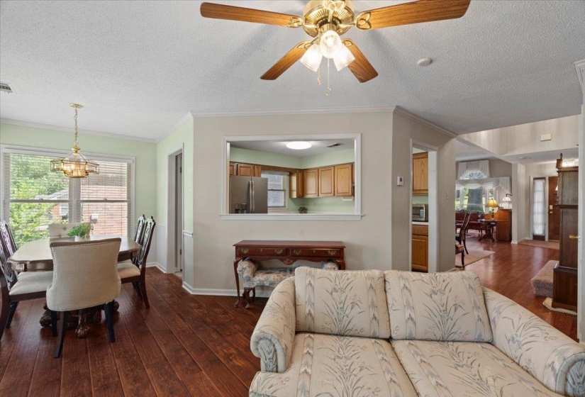 Dining area featuring wood-finish flooring, a contemporary chandelier, and a window with blinds