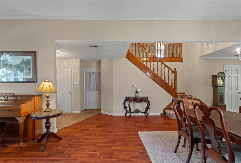Spacious interior featuring wood-finish flooring, a grand staircase with wood railings, and neutral wall tones