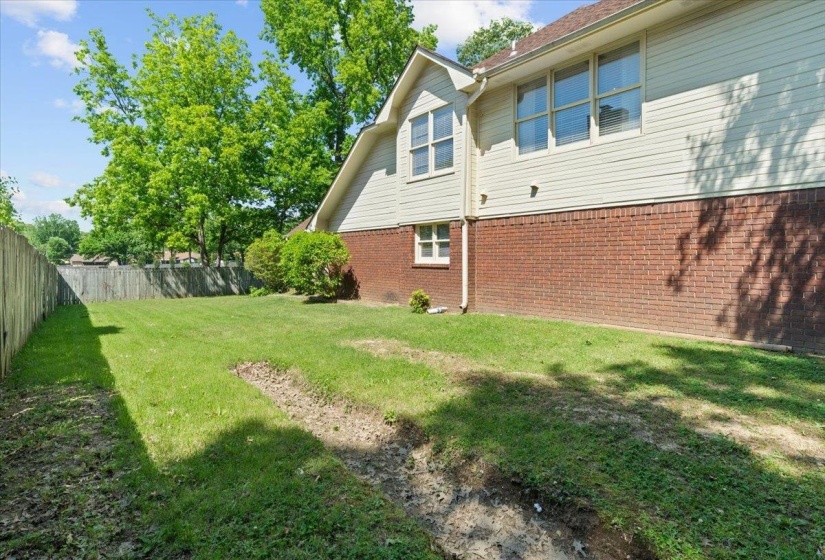 Spacious grassy yard featuring a wood fence perimeter