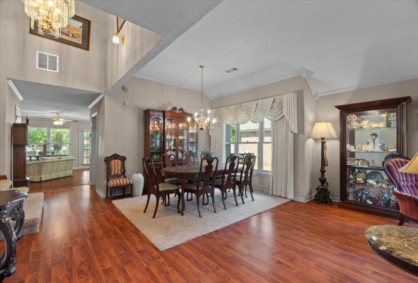 Spacious dining area featuring wood-finish flooring, a vaulted ceiling, and ample natural light from the large window
