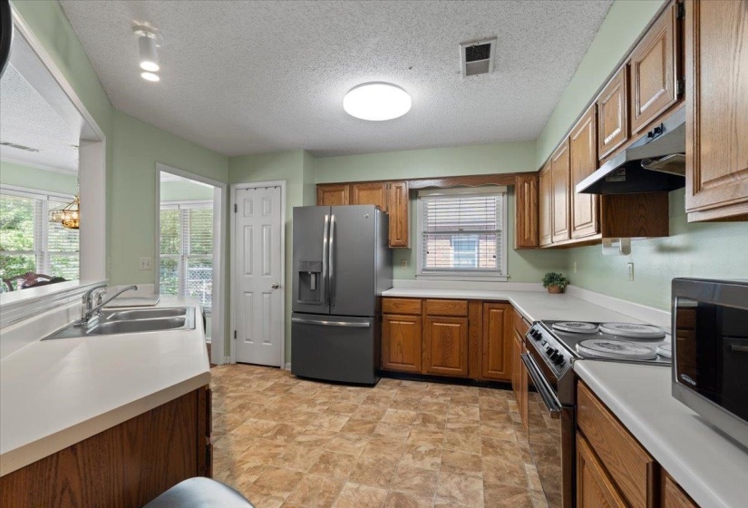 Kitchen featuring wood cabinetry, light-toned countertops, and durable flooring