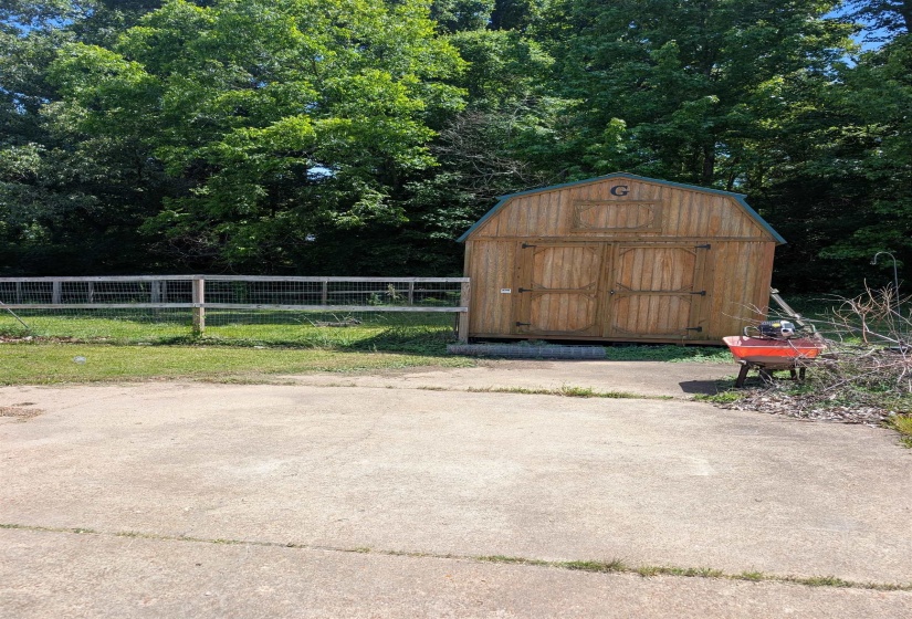 Barn-style shed featuring natural wood siding and a gambrel roof