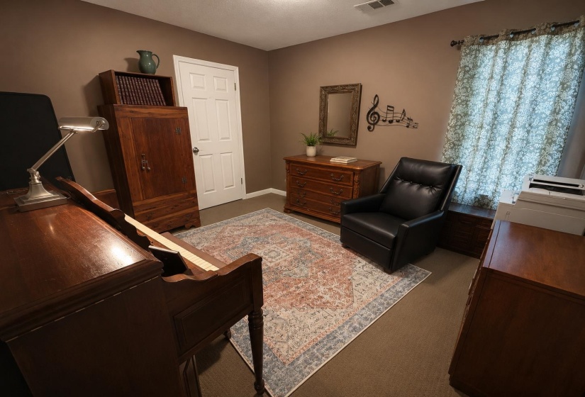 Interior room featuring neutral wall color, carpet flooring, a white paneled door, and a window with patterned drapes