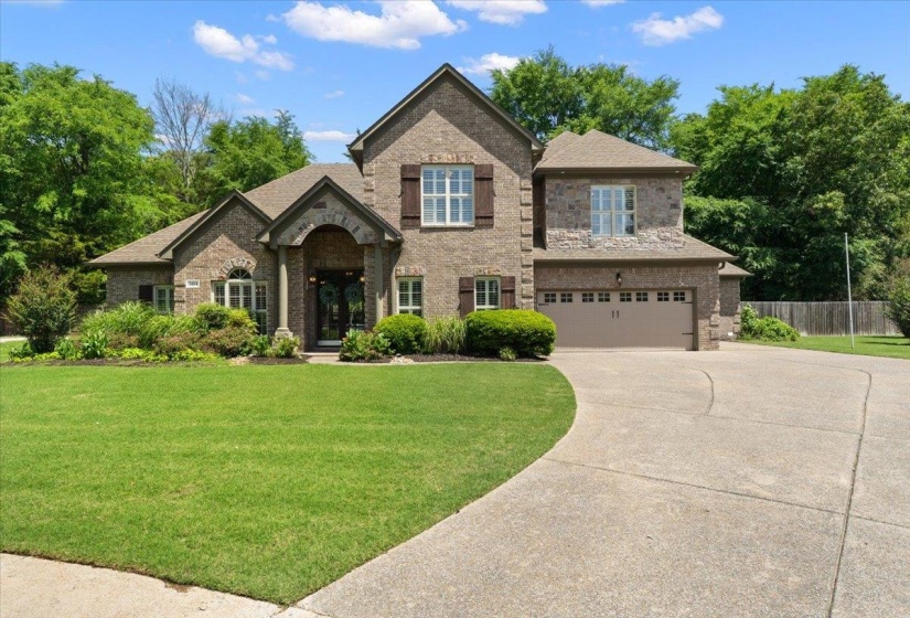Brick and stone exterior featuring a covered entry, gabled rooflines, and a two-car garage