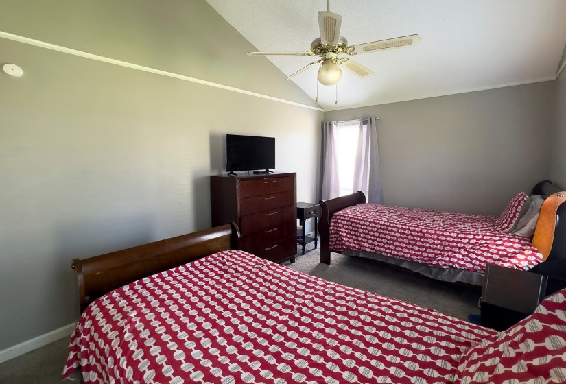 Vaulted ceiling with an overhead light fixture and ceiling fan