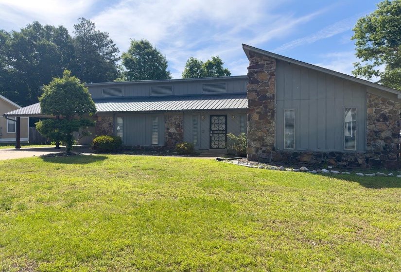 Stone and vertical siding exterior with a distinctive angled roofline and a metal roof
