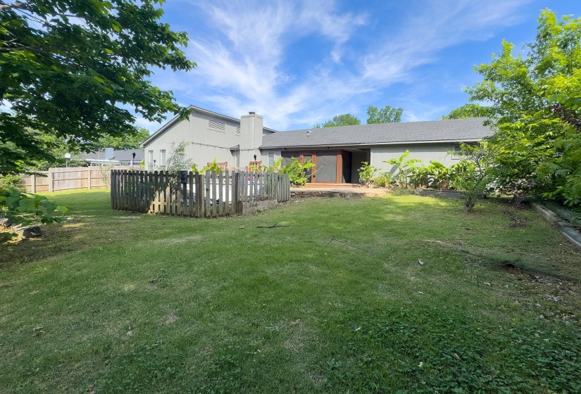 Expansive backyard with a manicured lawn, a privacy fence, and mature trees
