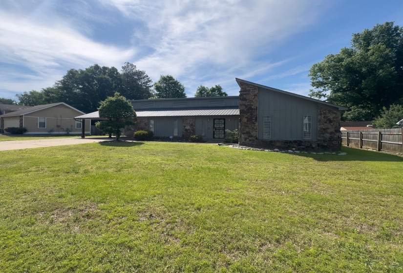 Contemporary exterior featuring a metal roof, stone accents, and vertical siding