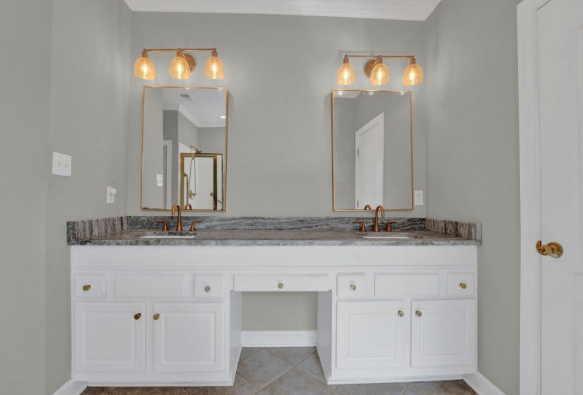 Bathroom featuring dual vanity, ornamental molding, and tile patterned floors