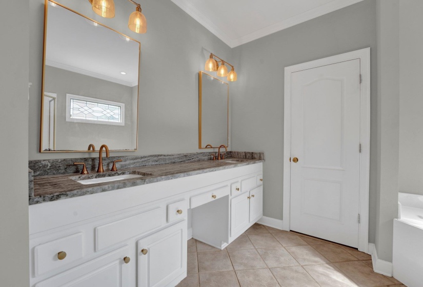 Bathroom with tile patterned floors, crown molding, and dual bowl vanity