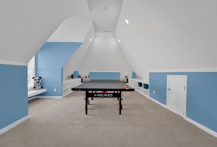 Playroom with lofted ceiling and carpet floors