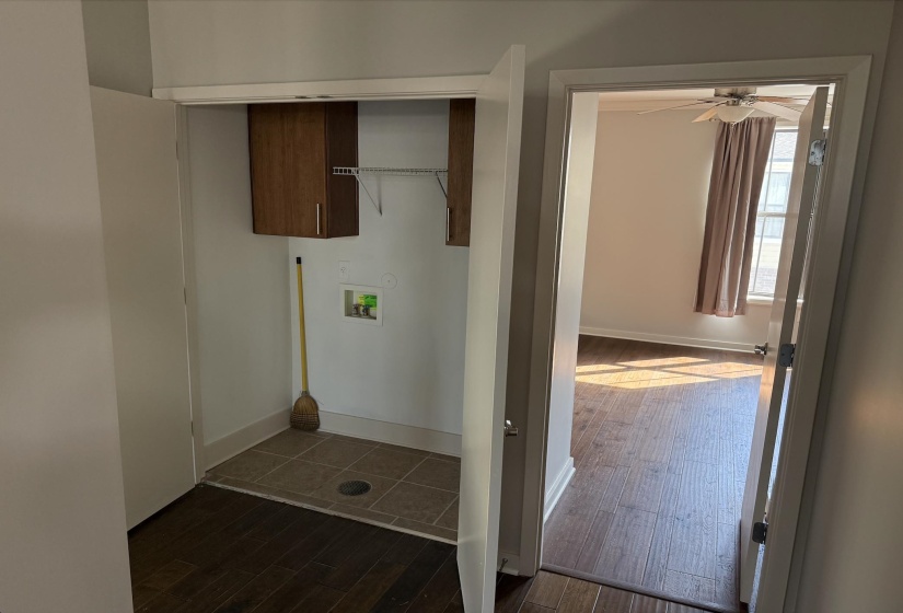 Laundry room with cabinet space, shelving, and dark tile patterned floors