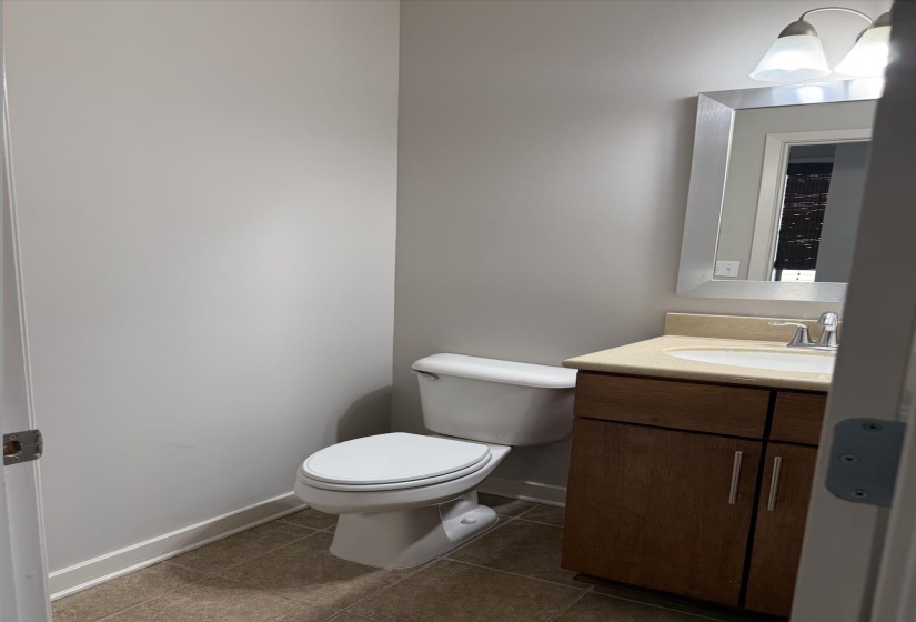 Half bath with vanity and dark tile patterned floors