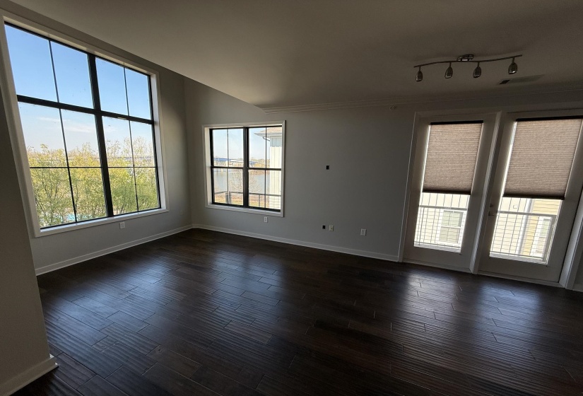 Room featuring dark wood-style flooring and large windows with panoramic views of downtown Memphis