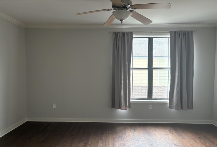 Spare room with ornamental molding, dark wood-style flooring, and ceiling fan